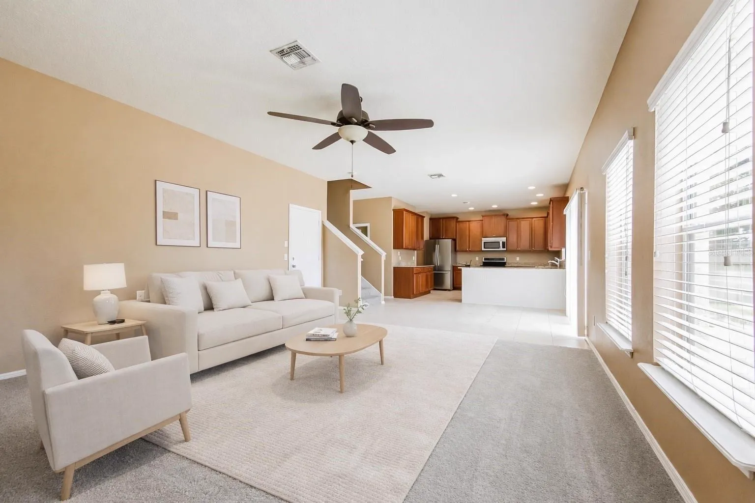 Living room at the Cheval Street home in Mount Dora, Florida, staged with furniture and an open floor plan flowing into the kitchen