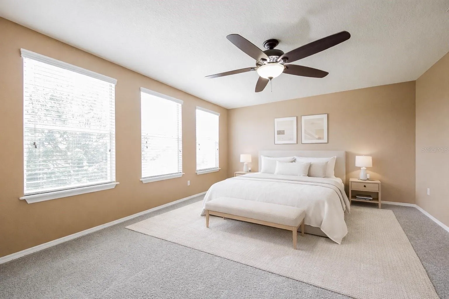Primary bedroom at the Cheval Street home in Mount Dora, Florida, staged with a bed, bench, and nightstands