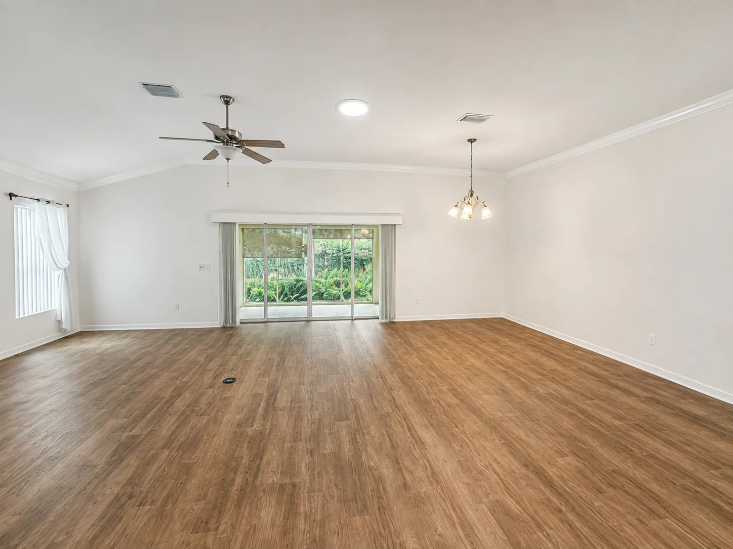 Open living and dining area with wood-look flooring and sliding glass doors