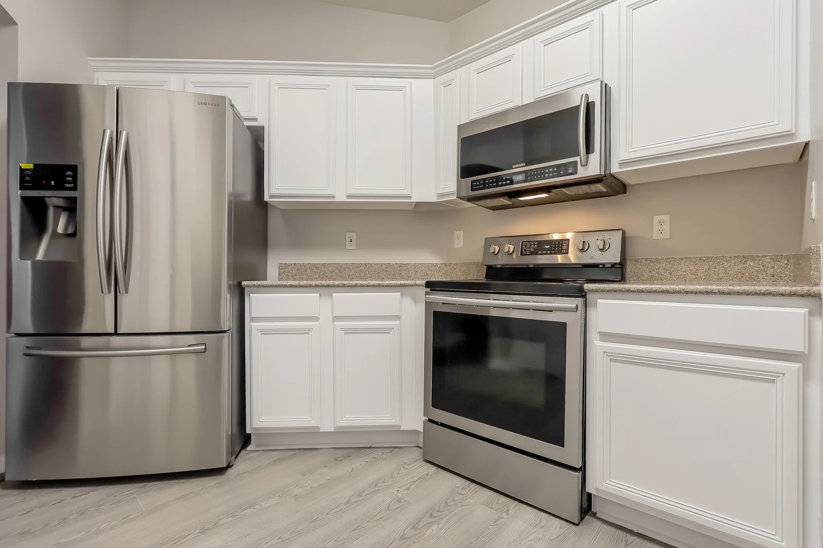 Kitchen at the Tee Shot Drive home with white cabinetry, granite countertops, and stainless steel appliances